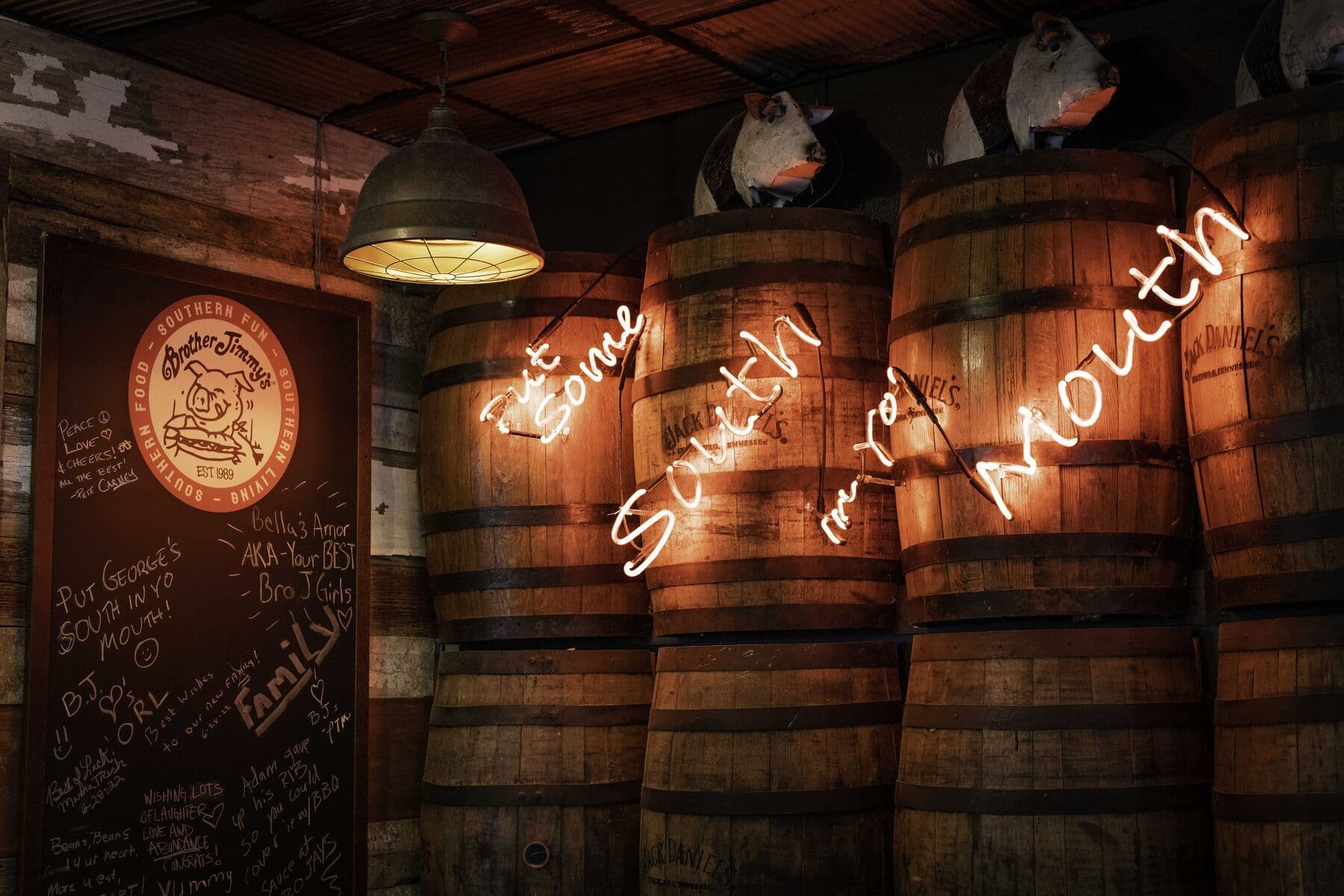 Neon signs glowing over the bourbon barrels
