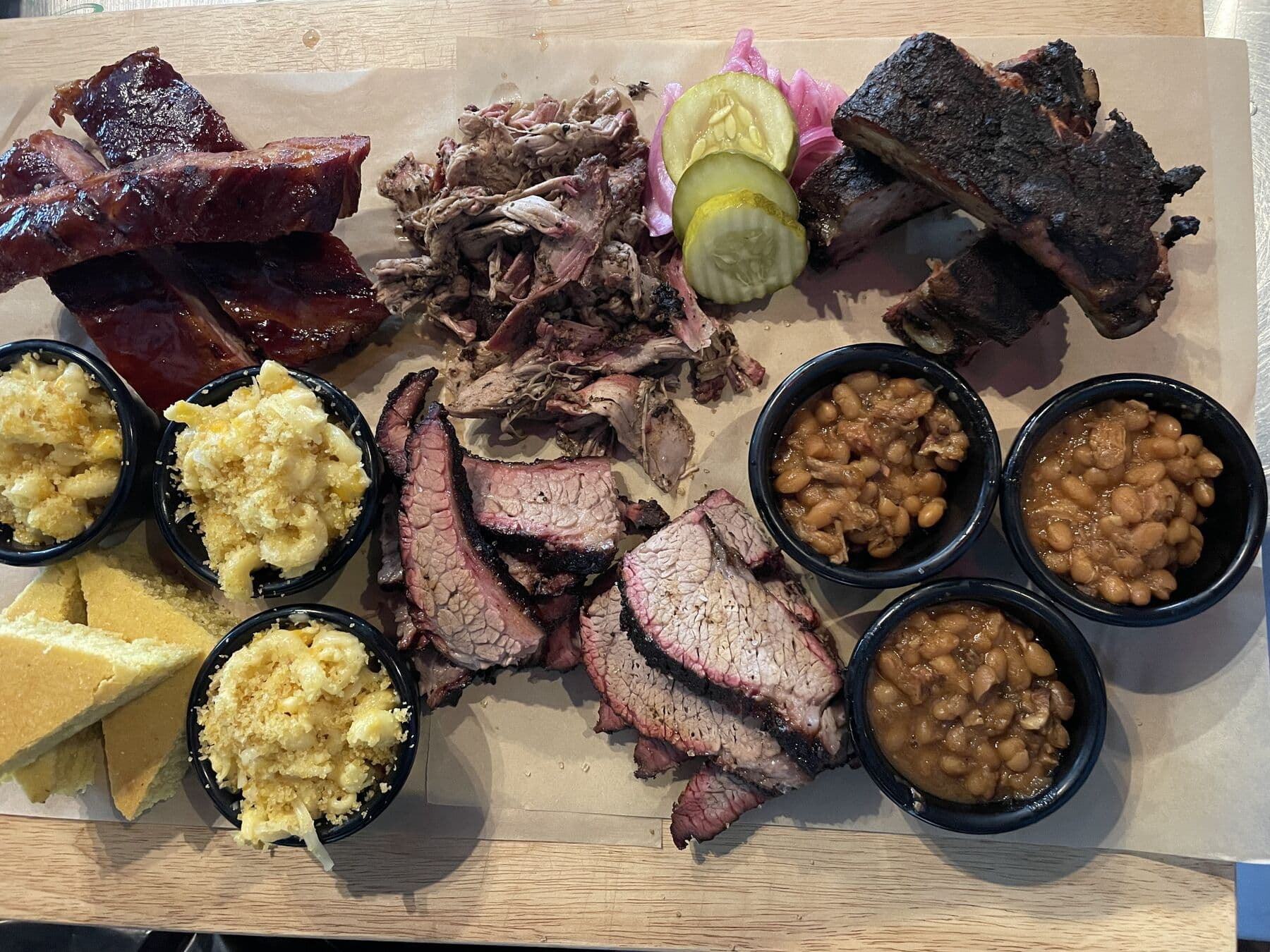 Platter of brisket, ribs and pulled pork with sides